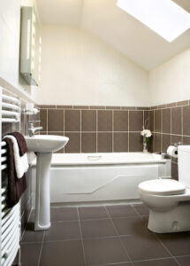 bathroom with brown tiles and white fixtures