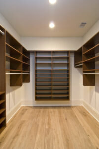 large walk-in closet with dark wood shelving